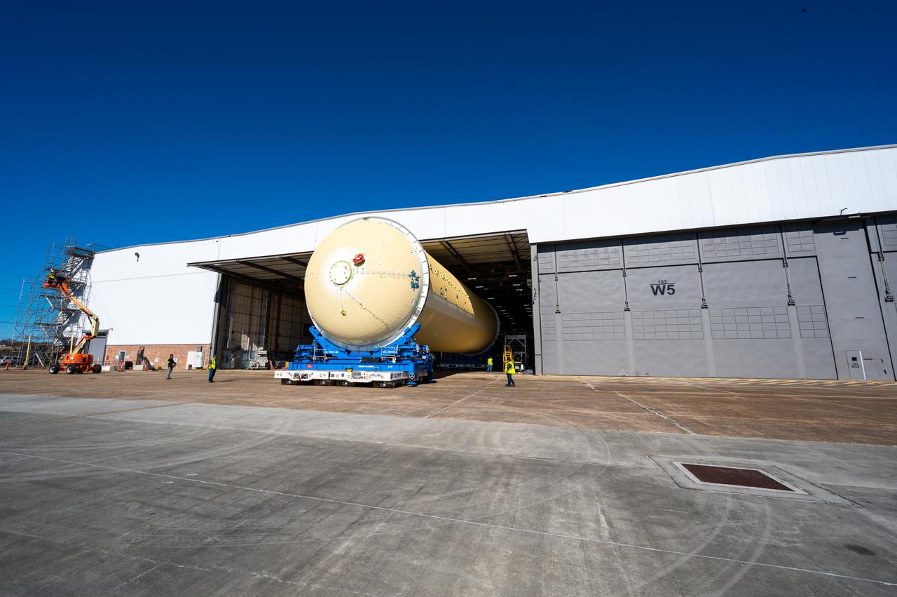 Technicians transported the assembled upper part of the Artemis II core stage to the final assembly area inside the factory at NASA’s Michoud Assembly Facility in New Orleans.  On Jan 10, the forward assembly, left was moved next to the Artemis II liquid hydrogen tank, which has been undergoing assembly. Next, Boeing, the lead core stage contractor, will join the forward assembly and the liquid hydrogen tank to complete most of the core stage for the Space Launch System (SLS) rocket that will send the first crew on an Artemis mission. The core stage consists of five major structures that are built, outfitted, and then connected to form the final stage. The forward skirt, liquid oxygen and intertank were connected and tested to form the 66-foot forward assembly. After the forward assembly is joined with the 130-foot liquid hydrogen tank, only the engine section, the fifth piece of the stage, will need to be added to complete the Artemis II core stage.  The core stage serves as the backbone of the rocket, supporting the weight of the payload, upper stage, and crew vehicle, as well as the thrust of its four RS-25 engines and two five-segment solid rocket boosters attached to the engine and intertank sections. On Artemis II, the SLS rocket will launch the Orion spacecraft and a crew, sending them into lunar orbit, in preparation for later Artemis missions that will enable the first woman and first person of color to land on the Moon.